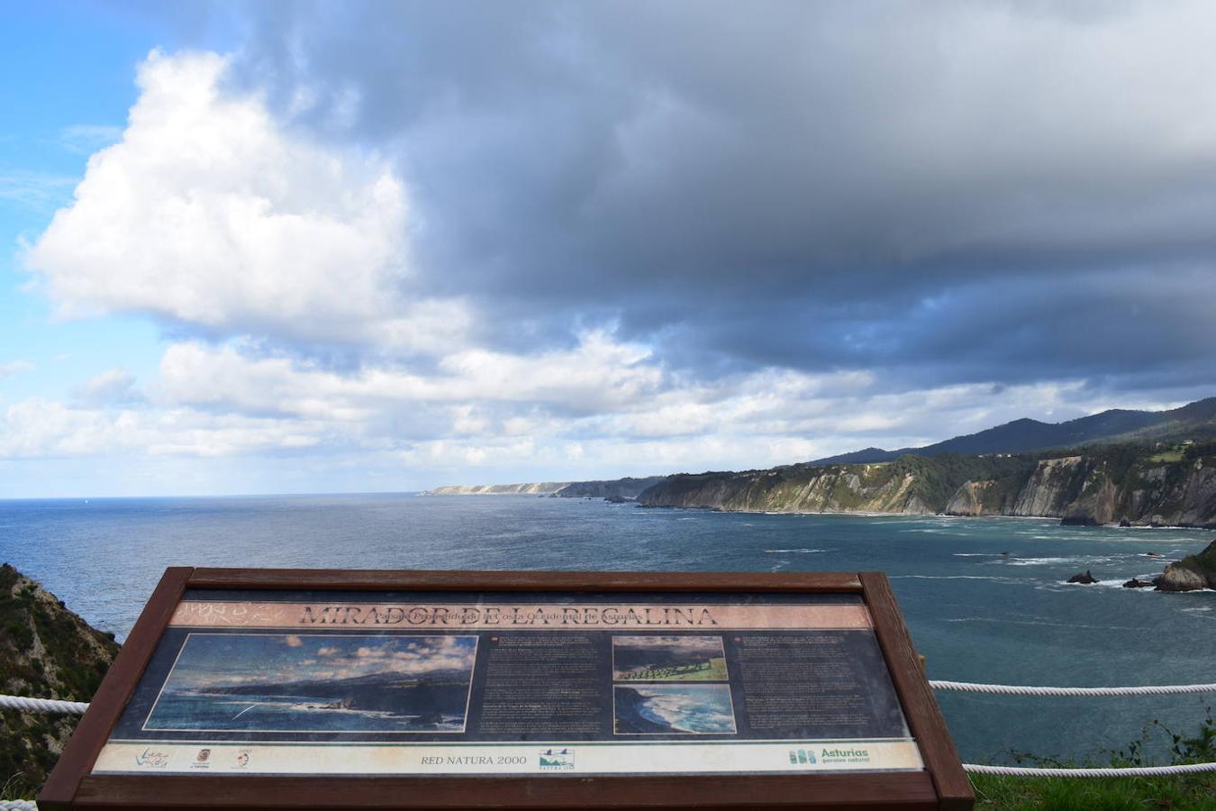 En el pueblo de Cadavedo y en pleno concejo de Valdés, es donde esta vez te acercamos y donde se encuentra el mirador de La Regalina, uno de esos lugares especiales que pueden encontrarse a ras de la costa asturiana y desde el que podrás disfrutar de una de las mejores vistas del occidente asturiano y del litoral. Un estupendo balcón en el que los pastos verdes tiñen de color un paisaje único y en el que la gran protagonista es una pequeña ermita de 1931 y dos hórreos, los cuales se encargan de presidir los acantilados de más de 70 metros sobre los que se ubica este mirador. Una panorámica única que nos acerca a ese Paisaje Protegido de la Costa Occidental Asturiana en el que se fusionan a la perfección mar y montaña, regalándonos unas vistas inigualables de la Playa de Cadavedo y Ribón y al arenal de Churín.