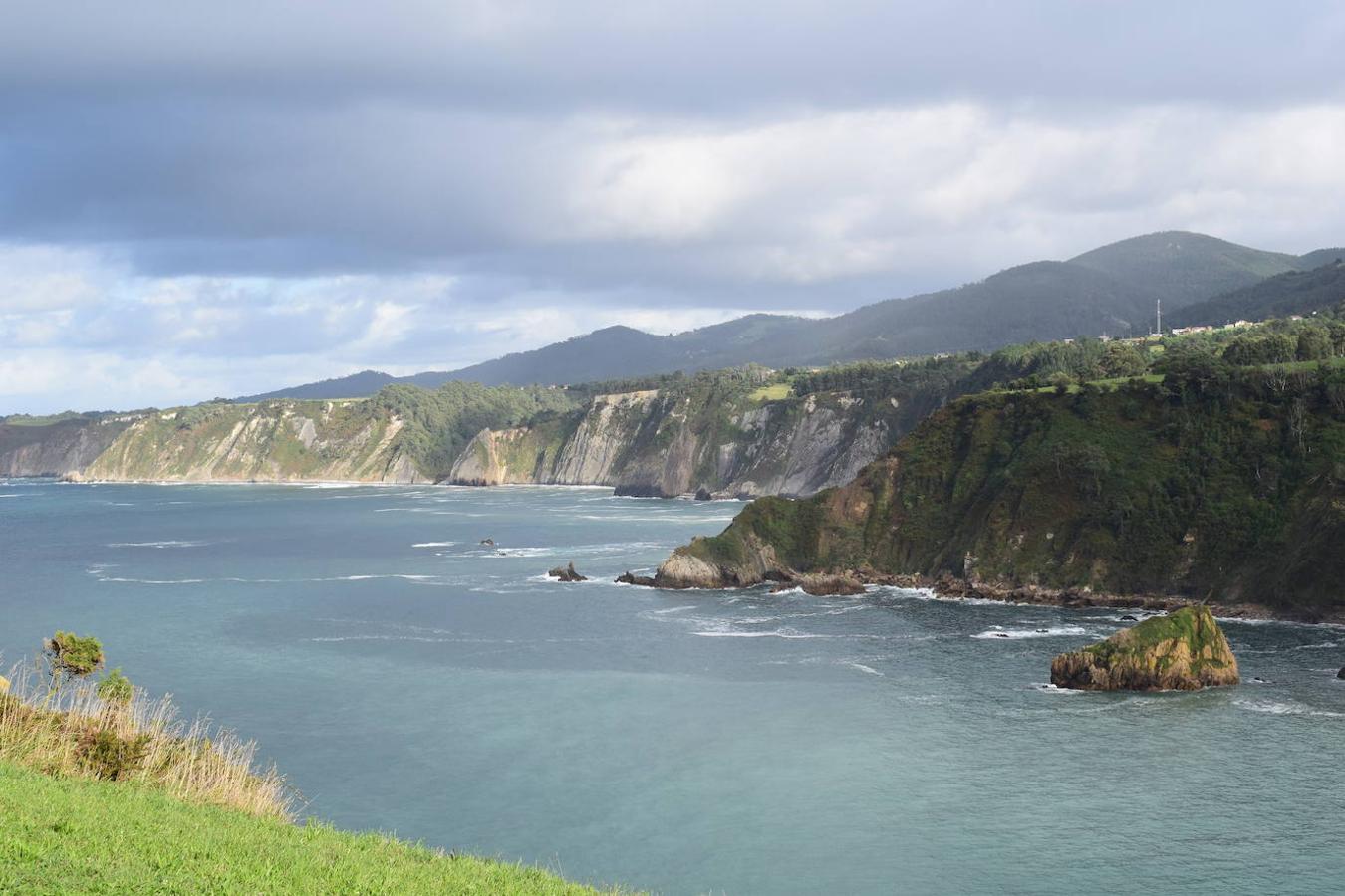 En el pueblo de Cadavedo y en pleno concejo de Valdés, es donde esta vez te acercamos y donde se encuentra el mirador de La Regalina, uno de esos lugares especiales que pueden encontrarse a ras de la costa asturiana y desde el que podrás disfrutar de una de las mejores vistas del occidente asturiano y del litoral. Un estupendo balcón en el que los pastos verdes tiñen de color un paisaje único y en el que la gran protagonista es una pequeña ermita de 1931 y dos hórreos, los cuales se encargan de presidir los acantilados de más de 70 metros sobre los que se ubica este mirador. Una panorámica única que nos acerca a ese Paisaje Protegido de la Costa Occidental Asturiana en el que se fusionan a la perfección mar y montaña, regalándonos unas vistas inigualables de la Playa de Cadavedo y Ribón y al arenal de Churín.