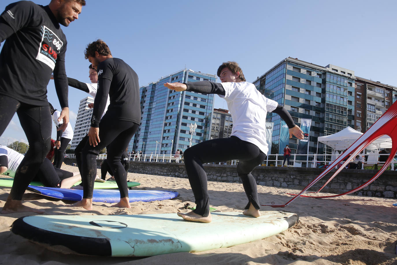 Una veintena de jóvenes con necesidades especiales han disfrutado este domingo de una colase de surf en el agua de la playa de San Lorenzo. La actividad, dedicada a miebros de la asociación Alarde y denominada 'Surf for Tomorrow', ha sido organizada por EdP y ha contado con la colaboración de la Escuela SkoolSurf. 