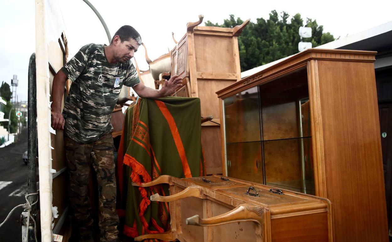 Un hombre coloca muebles en un camión durante la evacuación de La Laguna 