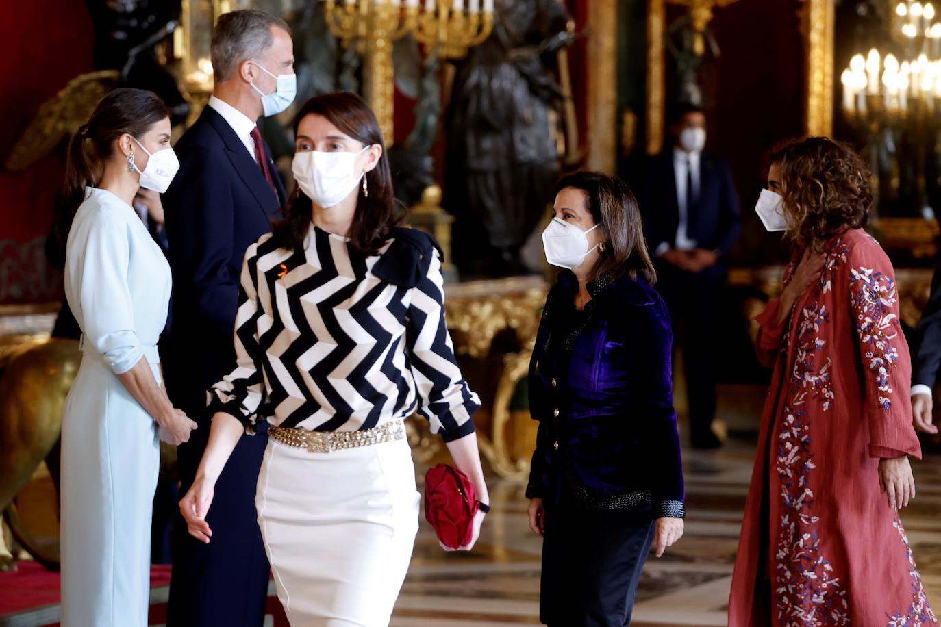 El Palacio Real de Madrid ha acogido la tradicional recepción que los Reyes ofrecen con motivo de la Fiesta Nacional y que el año pasado tuvo que suspenderse por la covid. Esta vez, el número inferior de invitados ha sido menor al habitual, unos 200, y ha sido imprescindible prescindir de bebidas y llevar la mascarilla para cumplir con las normas vigentes.