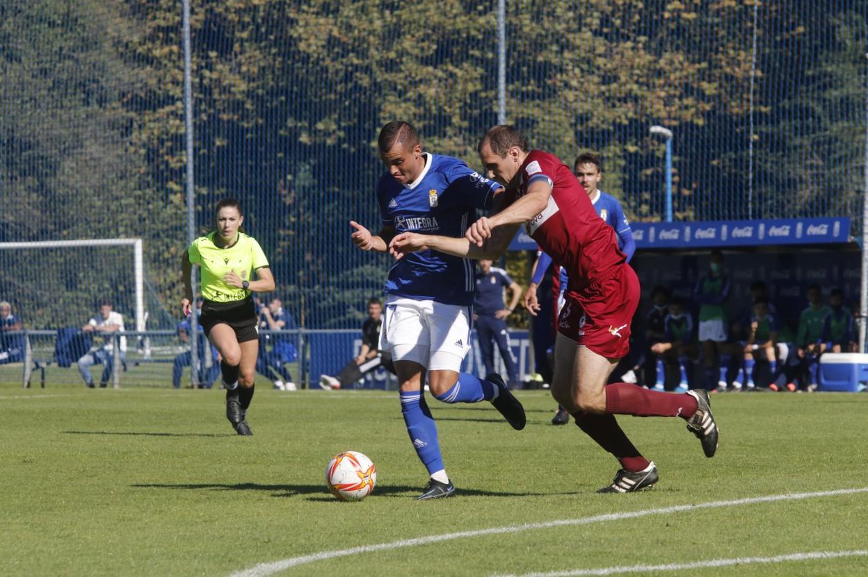 David Iglesias conduce ante la presión de Diego Suárez. 