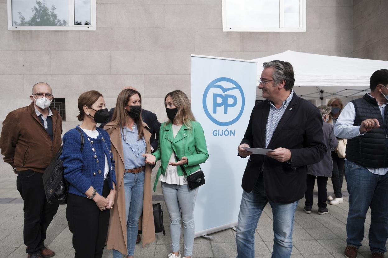 Ángeles Fernández-Ahúja, Ángela Pumariega, Cristina Villanueva y Pablo González, junto a la carpa donde voluntarios del PP recogen reclamaciones y sugerencias de los ciudadanos. 