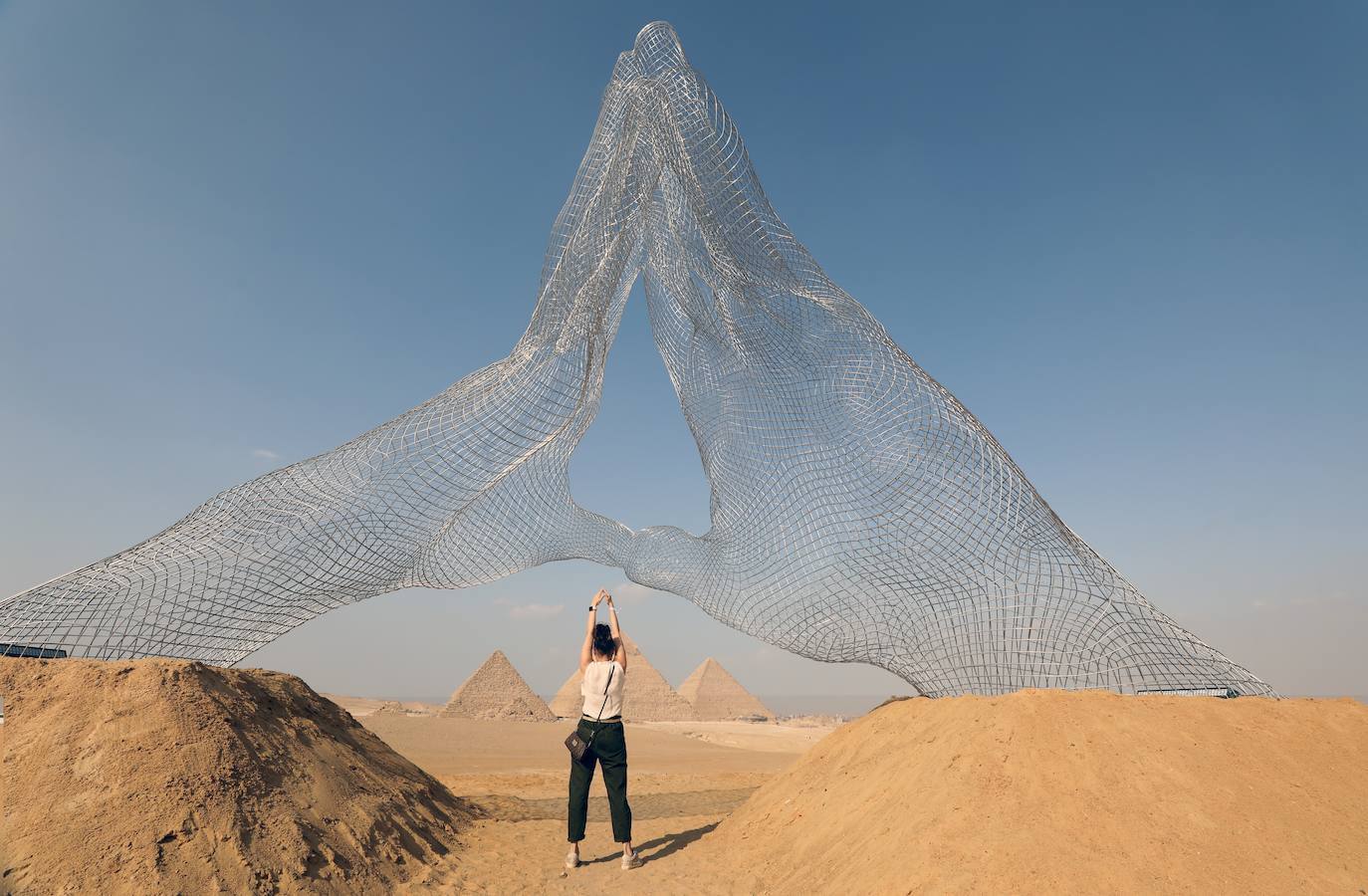 Las pirámides de Giza, Patrimonio de la Humanidad de la Unesco, cuentan con más de 4.000 años de antigüedad y son uno de los lugares más visitados del mundo. Pero ahora pueden verse como nunca antes, gracias a la exposición 'Forever Is Now', que recoge las obras de 10 artistas internacionales especialistas en la ilusión óptica, como Jean Rene (conocido como JR)