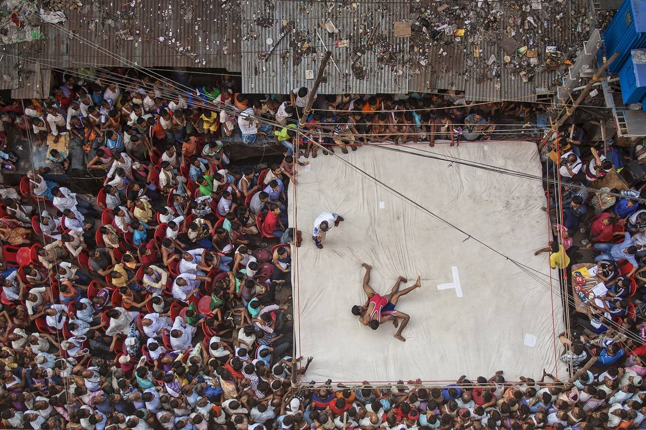 Deporte en acción. ‘Lucha callejera’, por Anupam Roy Chowdhury. Los luchadores locales luchan en un combate dentro del área del mercado Raja Katra en el barrio de Burrabazar. El torneo es organizado todos los años por el Burrabazar Bayam Samity con motivo del Diwali, uno de los festivales más importantes de la India. Cientos de personas se dieron cita para participar del evento deportivo.