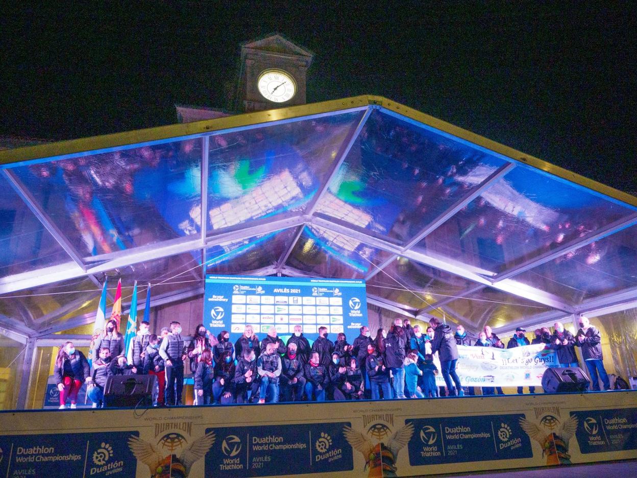 Foto de familia de los voluntarios en el escenario de la Plaza de España. 