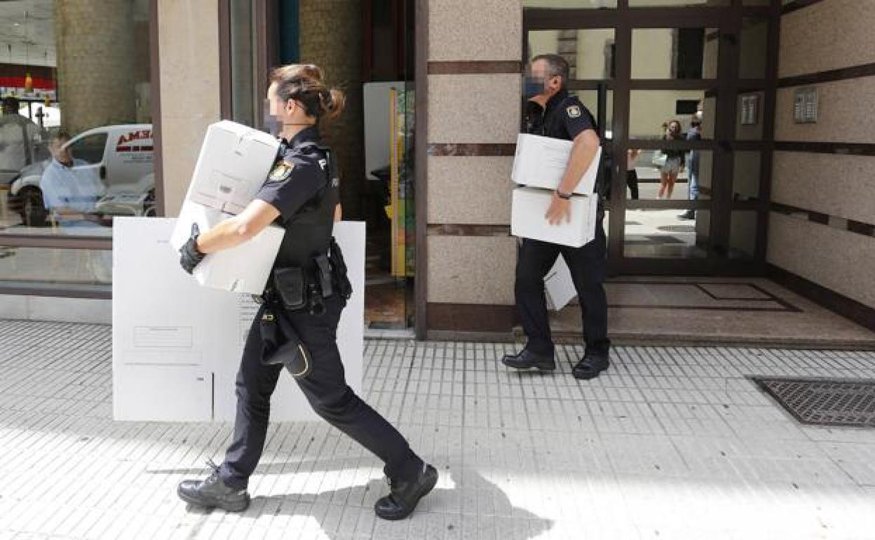 Agentes de la Policía Nacional sacan cajas de pruebas del lugar en el que dos jóvenes denunciaron una agresión sexual en Gijón el pasado mes de julio. 