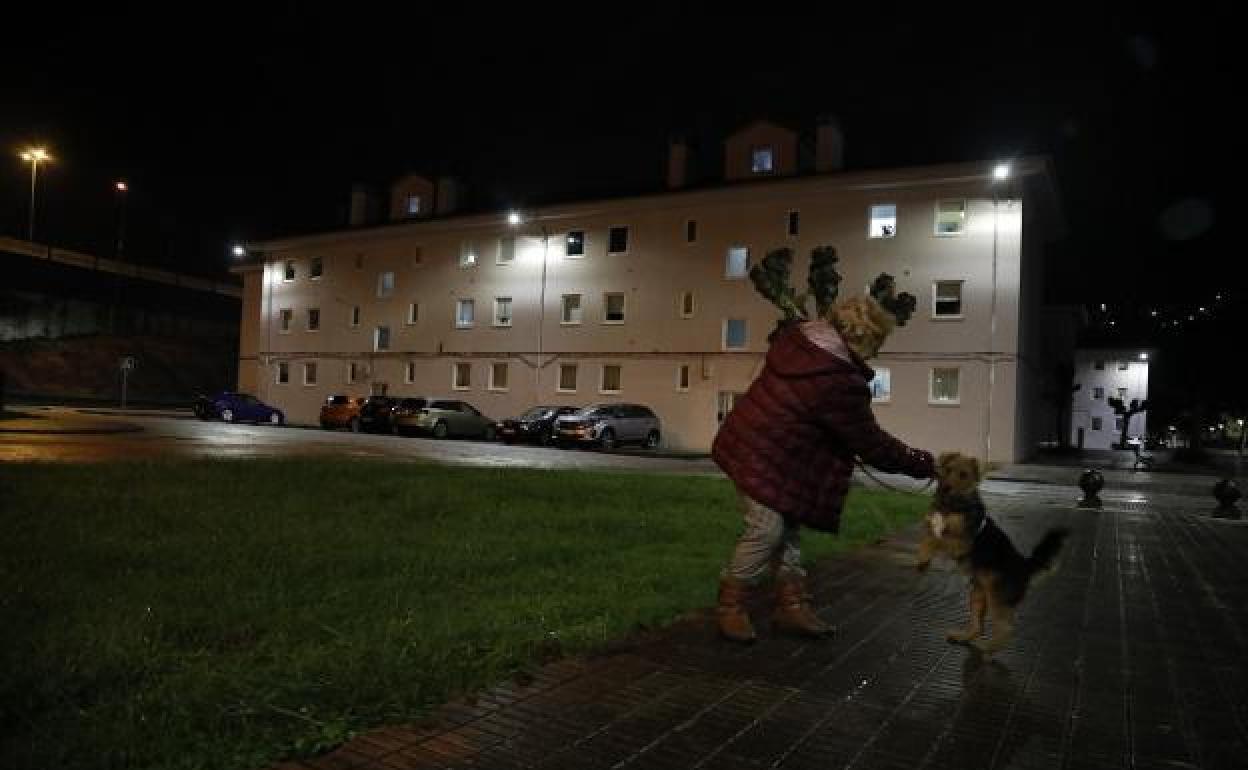 Una vecina, con su mascota, en el barrio San José del distrito langreano de Lada.