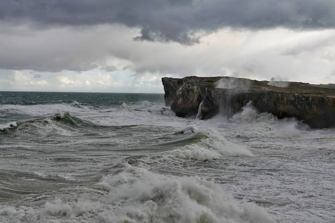 Las impresionantes olas y la fuerza del mar atraen a los curiosos, que pasean por los acantilados de Llanes y Ribadesella aprovechando para capturar el momento con sus fotografías. 