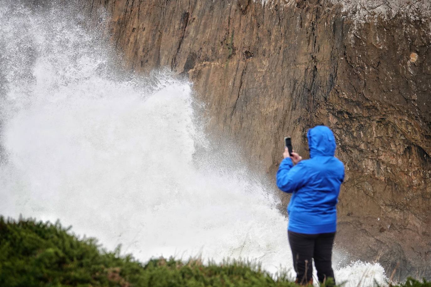 Las impresionantes olas y la fuerza del mar atraen a los curiosos, que pasean por los acantilados de Llanes y Ribadesella aprovechando para capturar el momento con sus fotografías. 