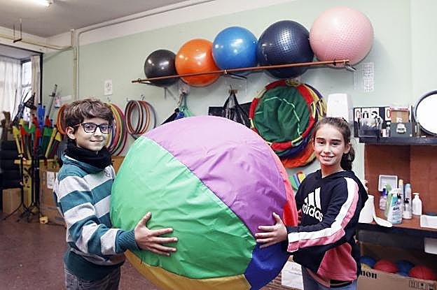 Martí Queipo y Olaya Megido, de sexto de Primaria, en la sala donde guardan el material.
