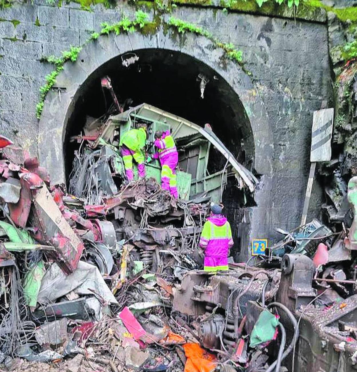 Cizalla de demolición hidráulica acometiendo a los vagones y la locomotora que taponaron el paso al túnel de Robledo en la rampa de Pajares. 