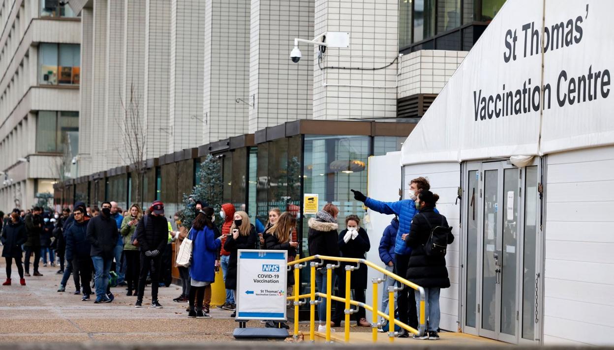 Jóvenes británicos hacen cola en el exterior del centro de vacunación abierto en el hospital St Thomas, en el centro de Londres. 
