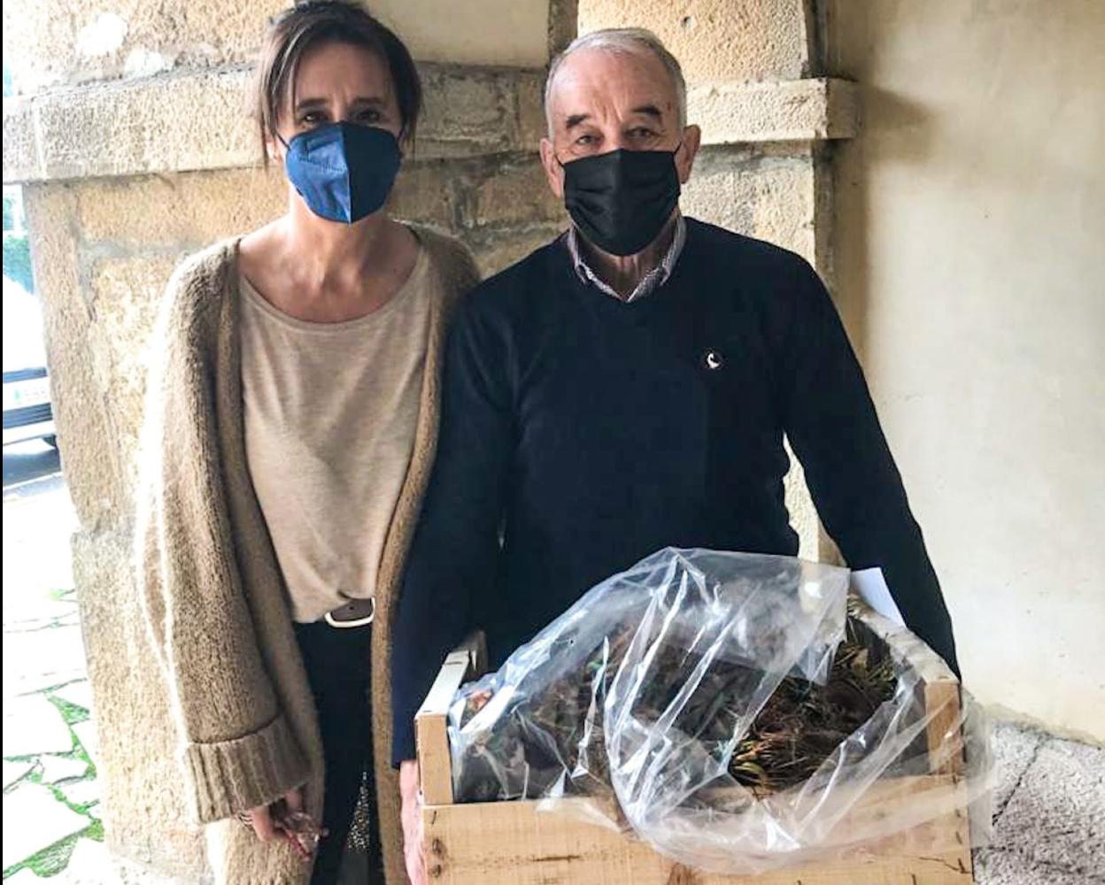 La edil Marta Menéndez entrega unos plantones a un agricultor local. 