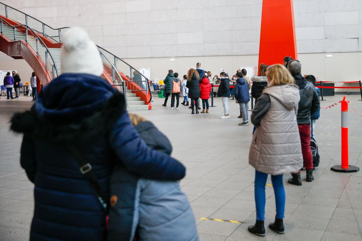 Una madre abraza a su hijo en la cola de espera para la vacunación infantil en Gijón. 