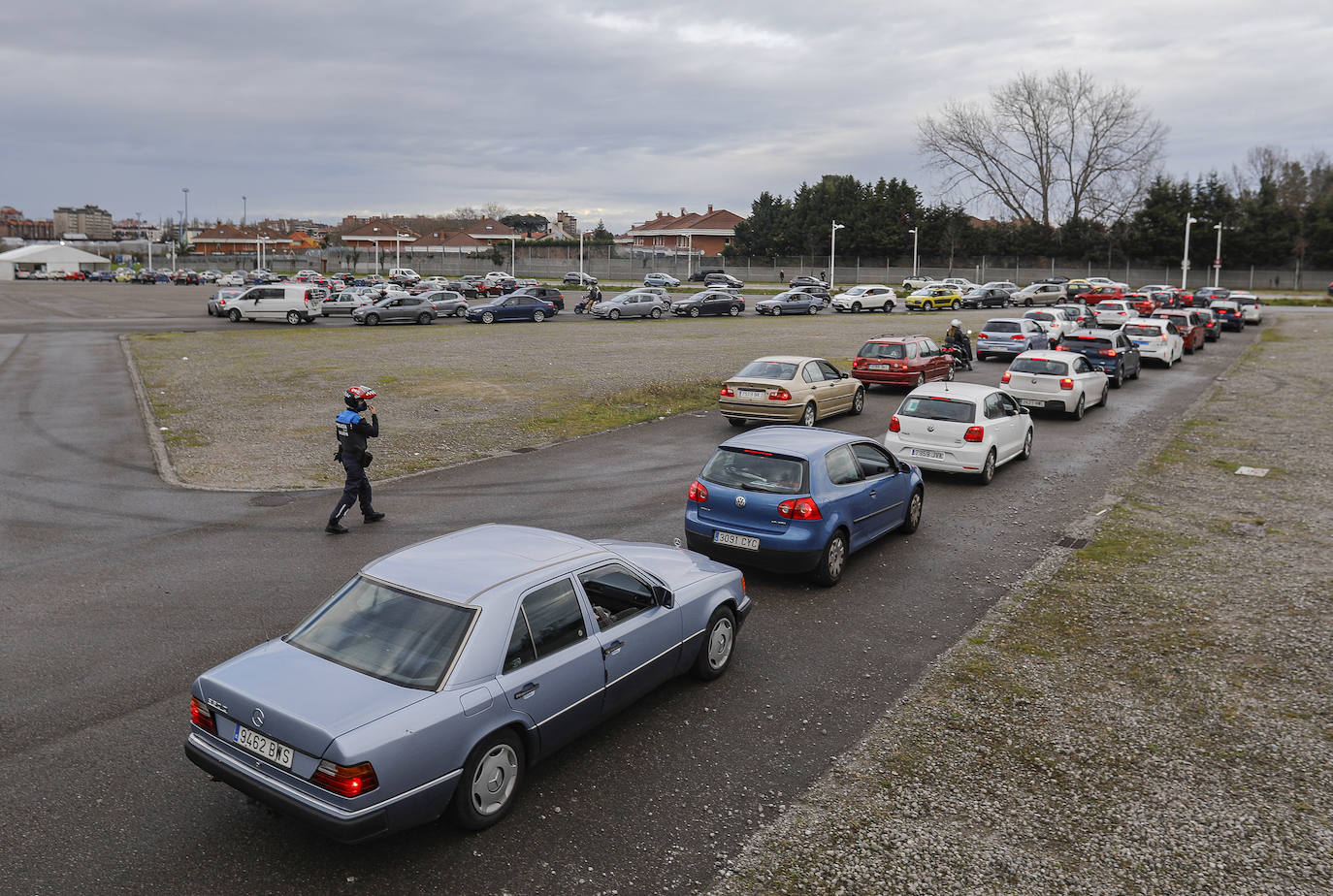 La actividad está siendo intensa en los autocovid de Gijón. Este mismo jueves, agentes de la Policía Local han tenido que acudir al instalado en la Marina Civil para formar una suerte de circuito y ordenar el tráfico. 