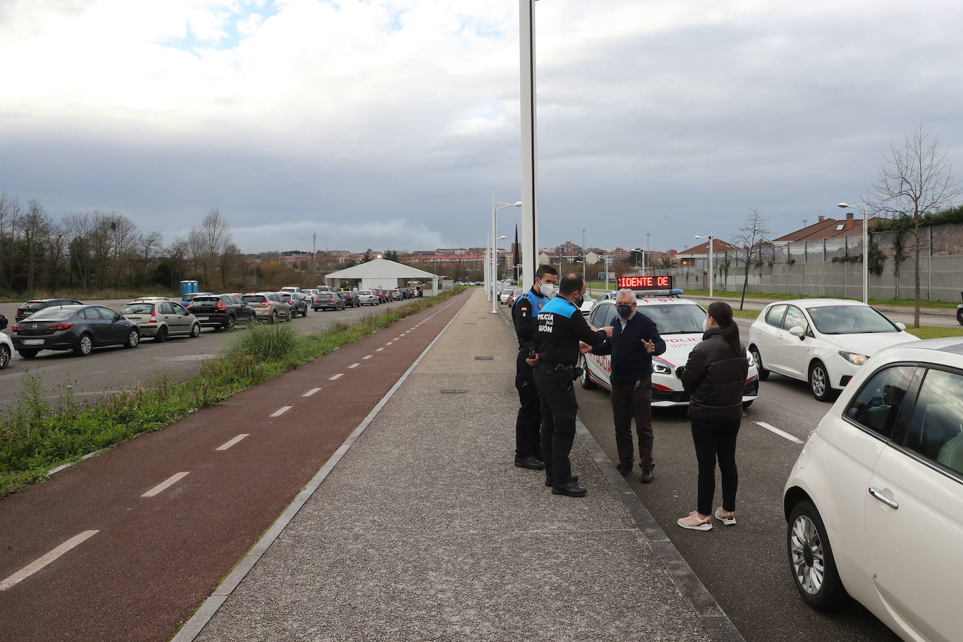 La actividad está siendo intensa en los autocovid de Gijón. Este mismo jueves, agentes de la Policía Local han tenido que acudir al instalado en la Marina Civil para formar una suerte de circuito y ordenar el tráfico. 