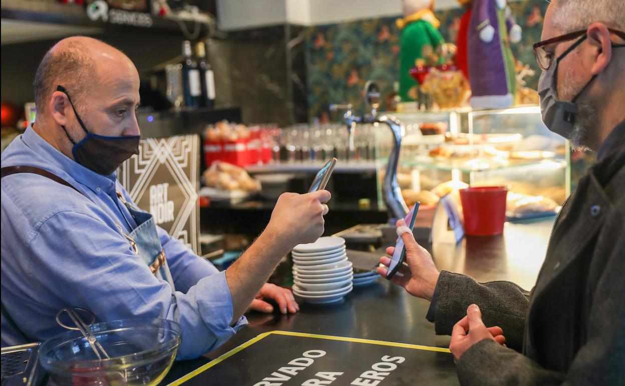 Un hostelero de Gijón comprueba el pasaporte de un cliente esta mañana.