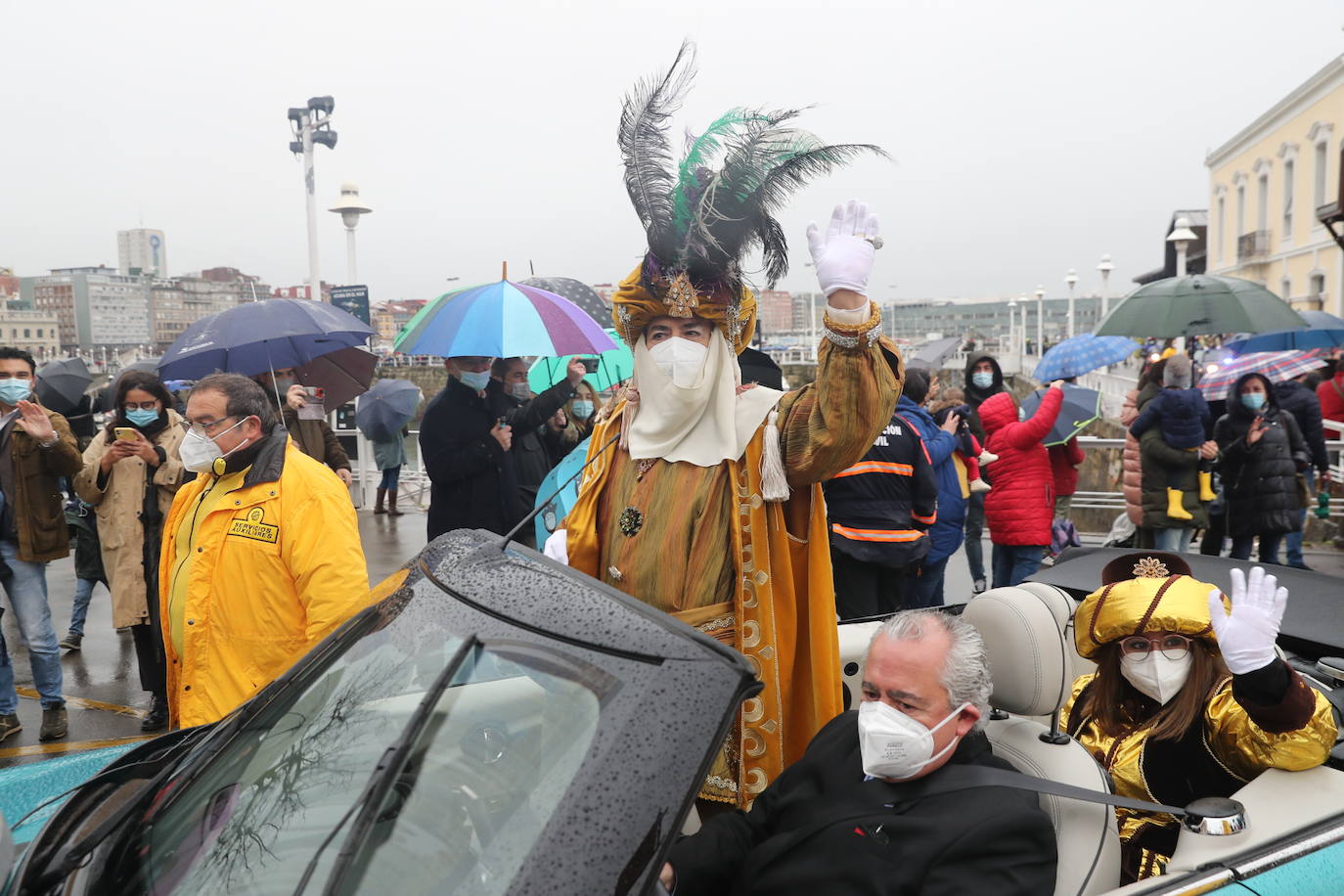 Los Reyes Magos atracaban en el puerto de Gijón bajo la lluvia sobre las 11 de la mañana mientras centenares de niños coreaban lo nombres de Sus Majestades.