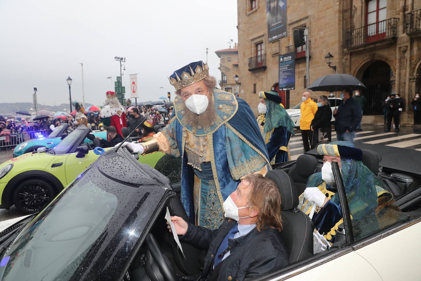 Los Reyes Magos atracaban en el puerto de Gijón bajo la lluvia sobre las 11 de la mañana mientras centenares de niños coreaban lo nombres de Sus Majestades.