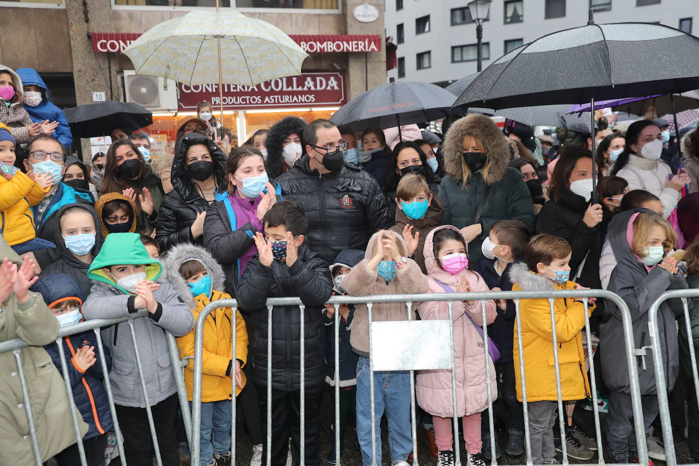 Los Reyes Magos atracaban en el puerto de Gijón bajo la lluvia sobre las 11 de la mañana mientras centenares de niños coreaban lo nombres de Sus Majestades.