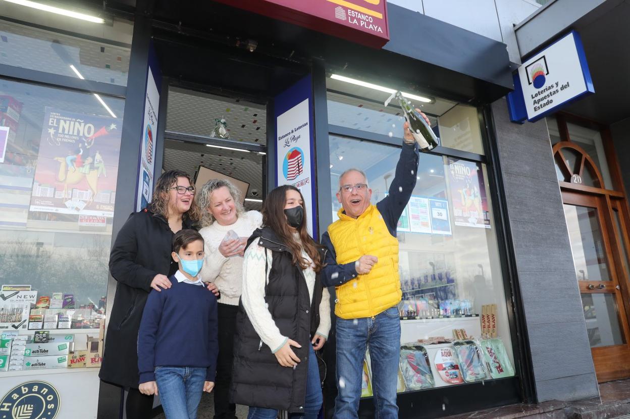 Eduardo Fernández descorcha el champán, junto a su mujer Bernardina Pérez y a sus tres hijos, Lucía, Ángela y Eduardo, a las puertas de su administración, en la calle Rufo García Rendueles. 