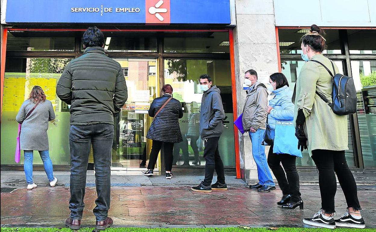 Ciudadanos esperan a la puerta de una oficina del Sepe, en Oviedo.