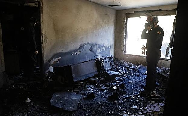 La Policía analiza la vivienda incendiada en La Felguera.