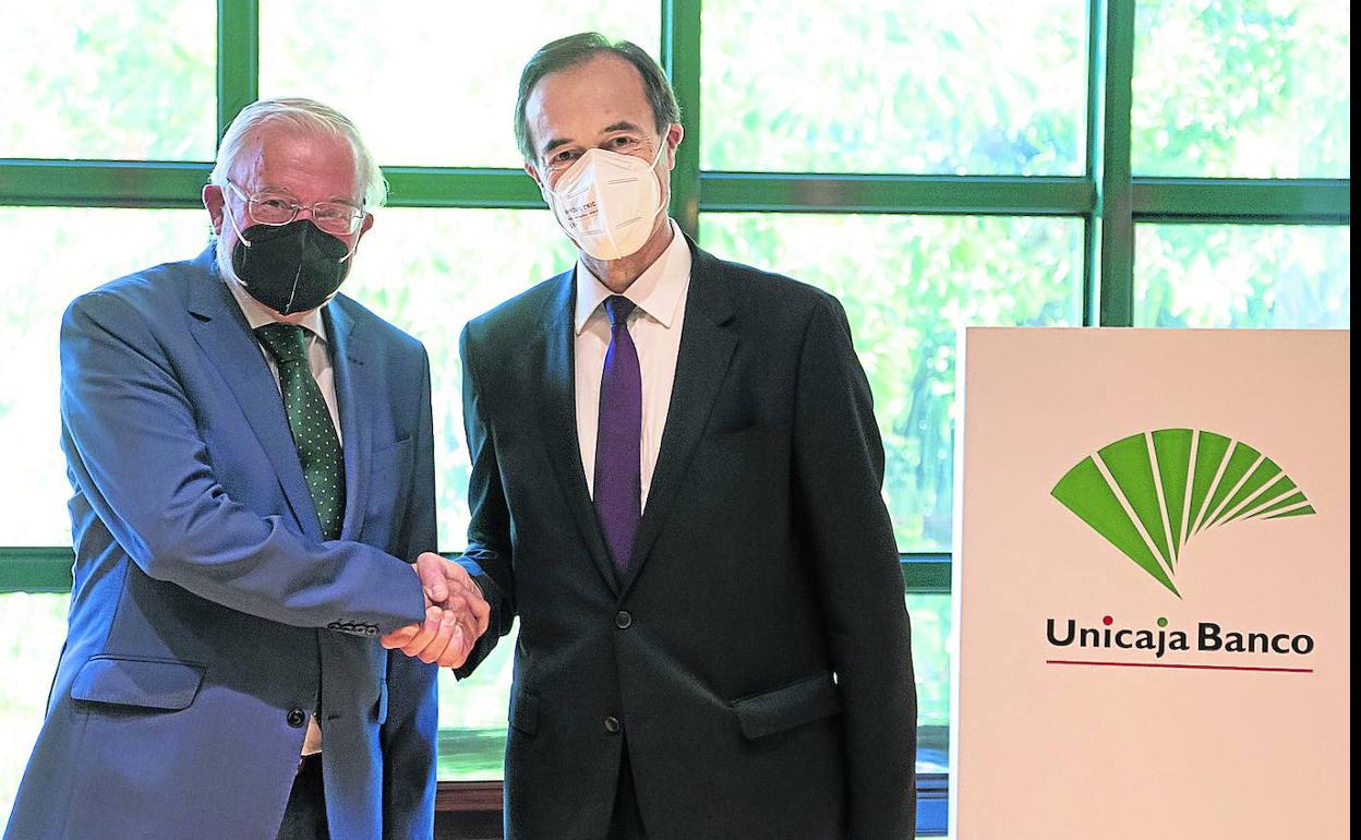 Manuel Azuaga y Manuel Menéndez en el acto de firma de escritura de la fusión de Unicaja y Liberbank en julio de 2021.