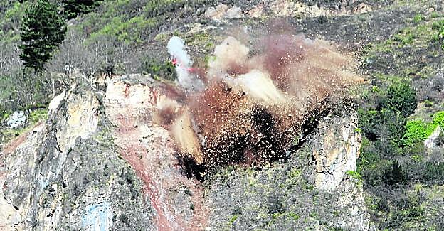 Momento de la detonación, ayer al meiodía, en la ladera sobre la AS-15 a su paso por la localidad de Soto de la Barca, en Tineo. 