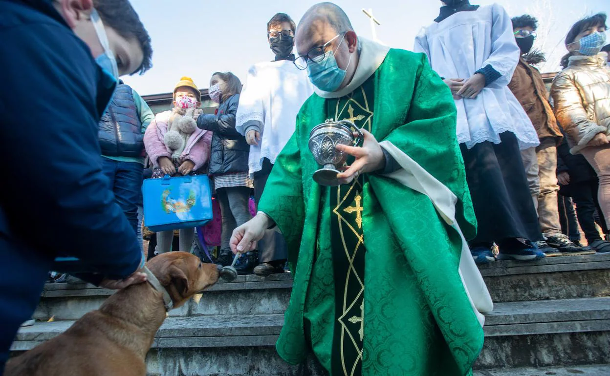 El párroco de La Magdalena, David Cuenca, bendice a un perro tras la misa de ayer. 