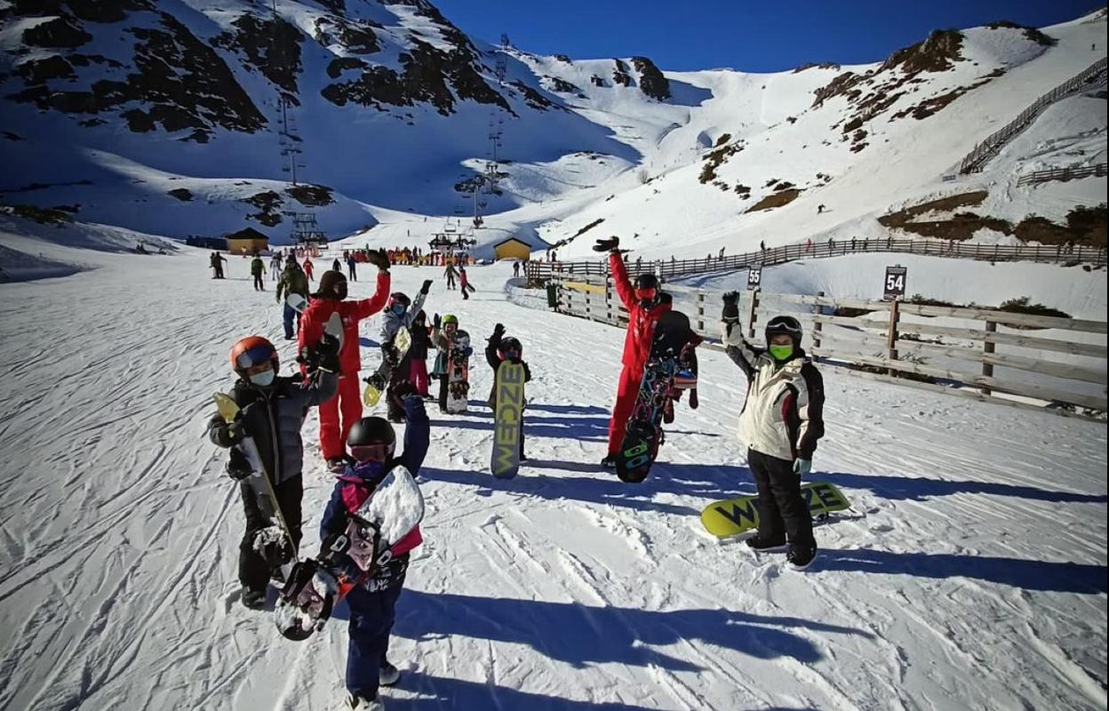 Unn grupo aprende snowboard en la estación de Fuentes de Invierno. 