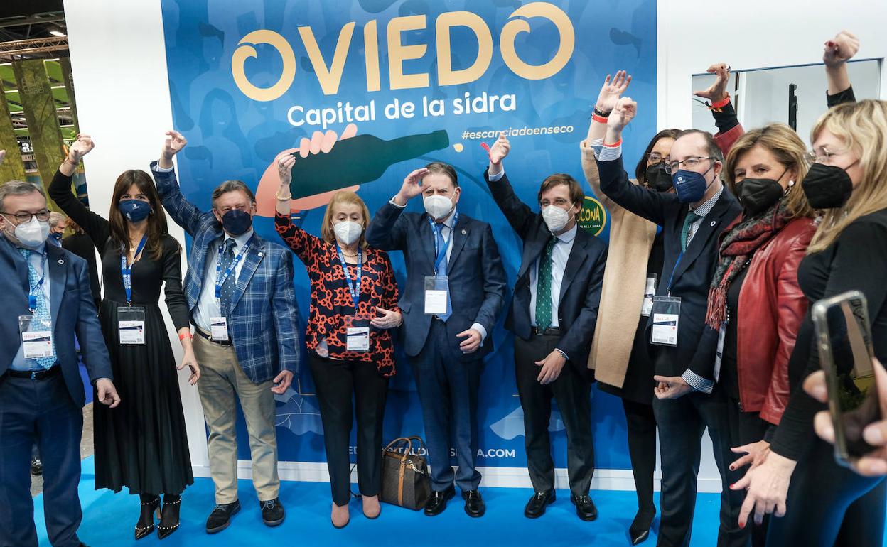 Los alcaldes de Oviedo y Madrid, Alfredo Canteli y José Luis Martínez Almeida, simulan escanciar un culín de sidra en Fitur acompañados de los concejales carbayones