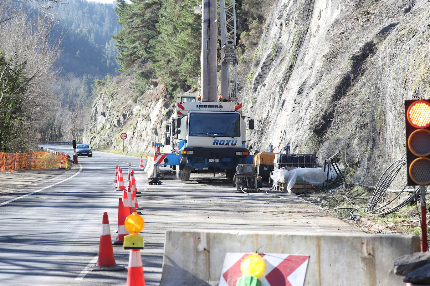 Fotos: Los operarios fijan los bulones y las redes de cotención en la AS-15