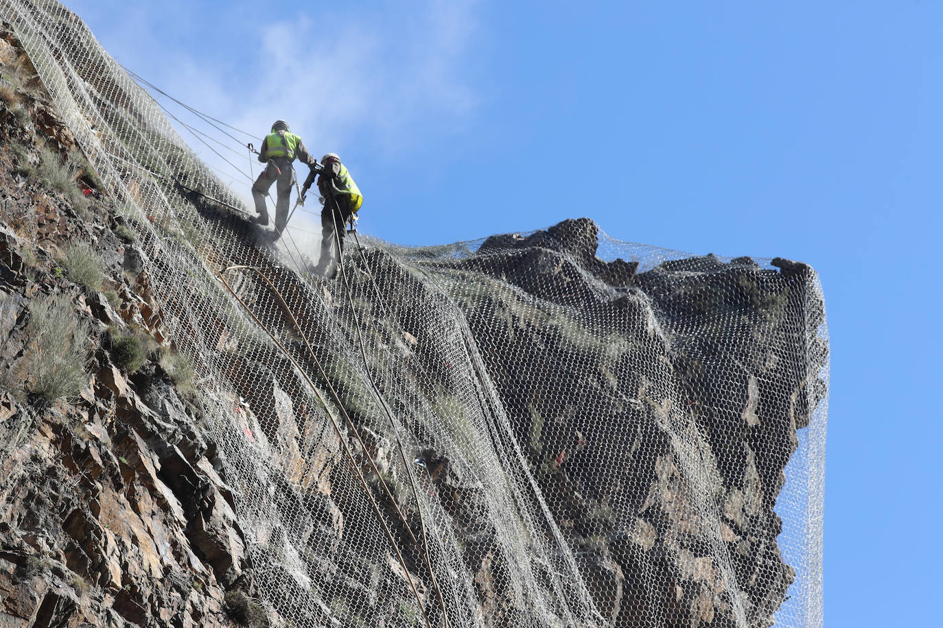 Fotos: Los operarios fijan los bulones y las redes de cotención en la AS-15