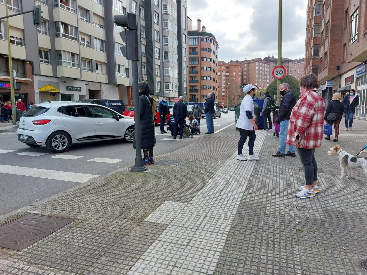 Agentes de la Policía Local y viandantes atienden a la víctima. 