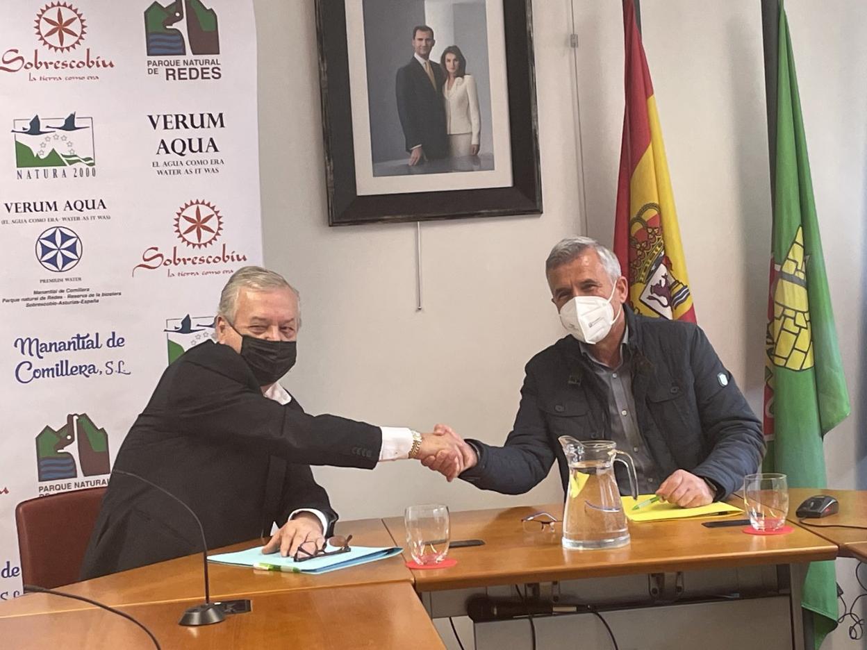El empresario Javier Menéndez y el alcalde de Sobrescobio, Marcelino Martínez, sellan el acuerdo de la planta embotelladora de agua.