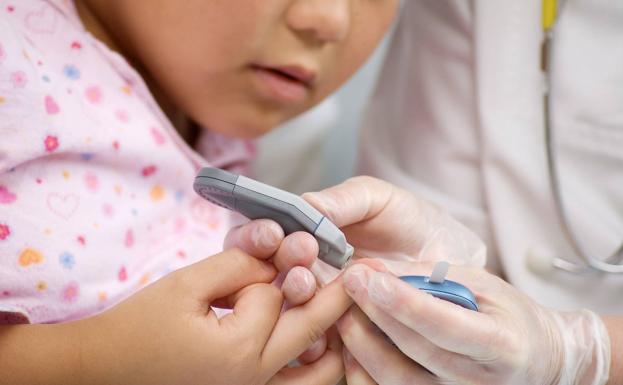 Un médico mide el azúcar en sangre a un niño 