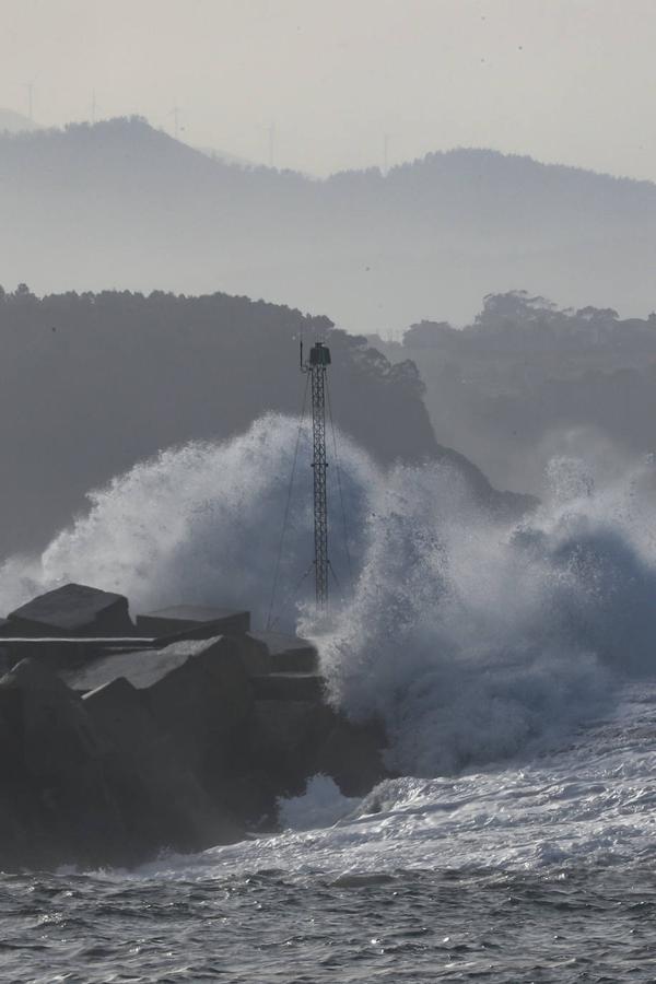 El faro de San Juan de Nieva estuvo rodeado de un fuerte oleaje durante la jornada de este jueves, en Avilés.