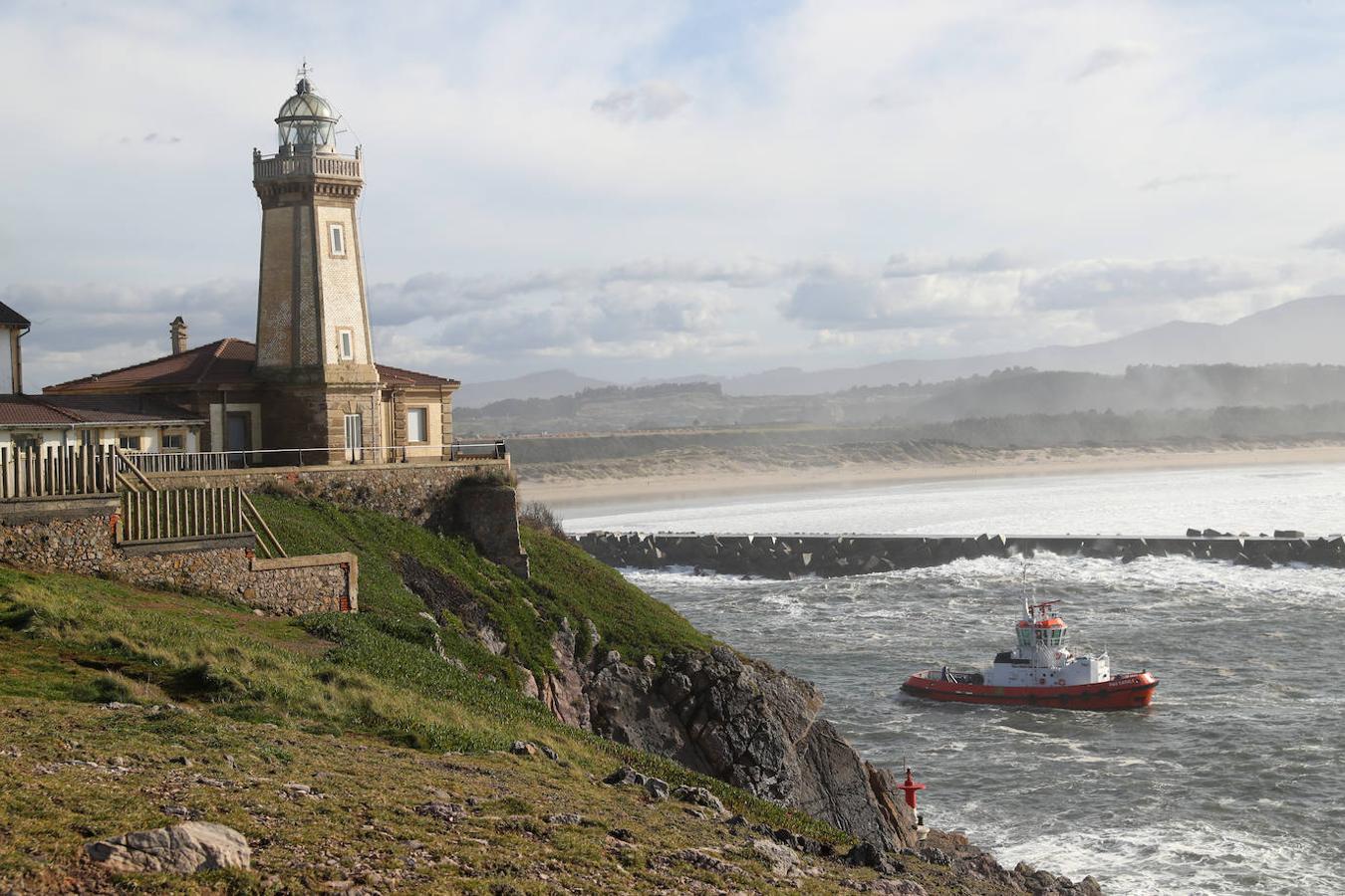 El faro de San Juan de Nieva estuvo rodeado de un fuerte oleaje durante la jornada de este jueves, en Avilés.
