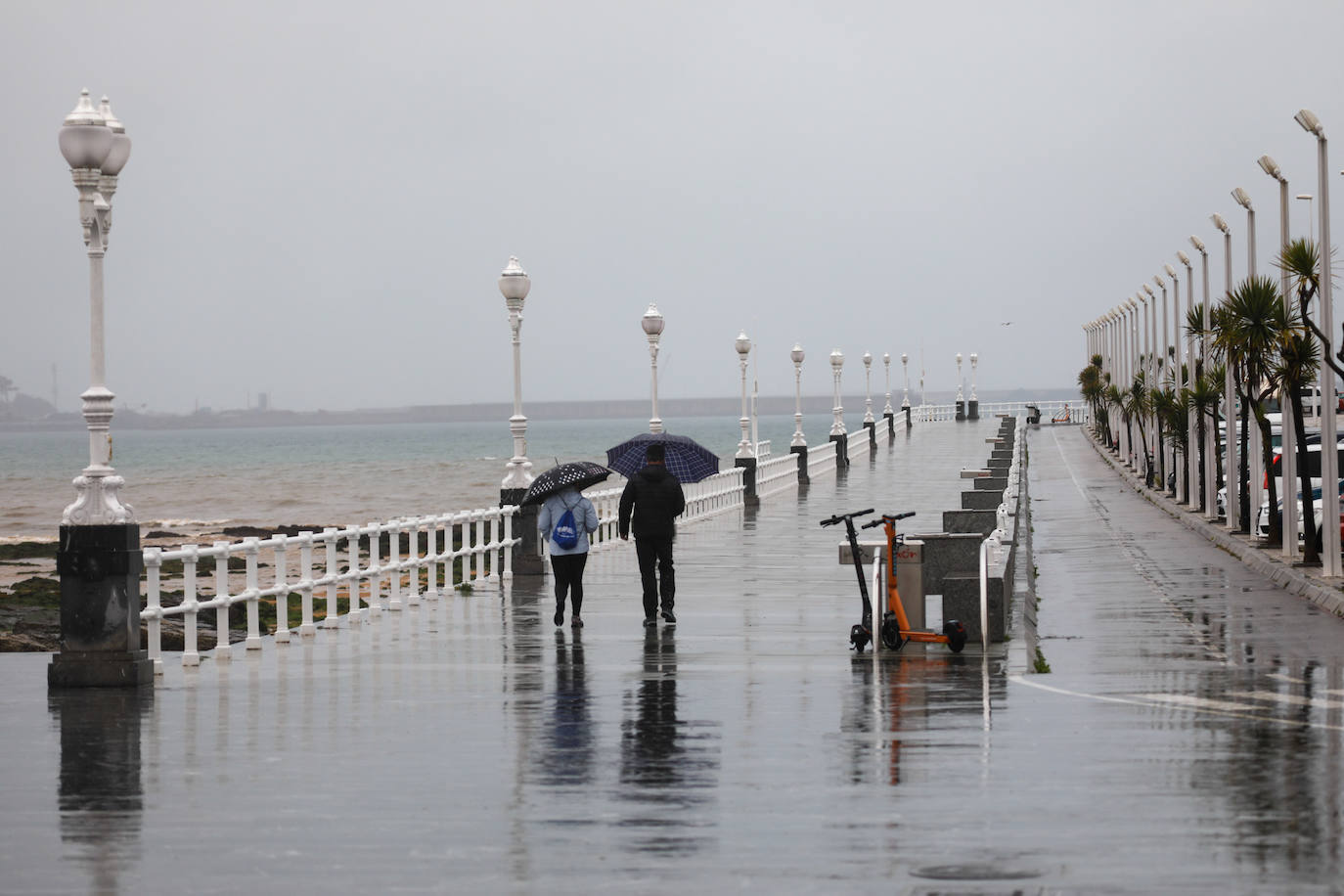 Tal y como anunciaba el pronóstico, Gijón amaneció este jueves con una meteorología invernal, bajo fuertes lluvias y con una notable descenso de las temperaturas