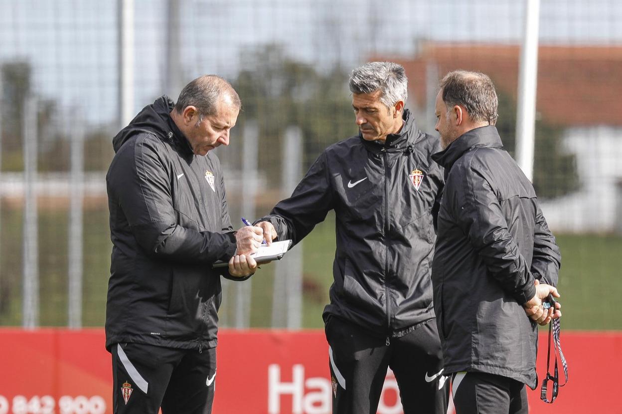 Martí señala el cuaderno de su segundo entrenador, Fabián Rivero, en presencia del preparador físico, Eduardo Domínguez. 