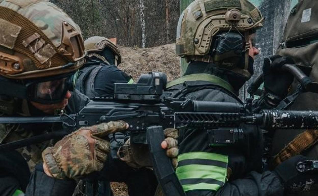 Un soldado pasa ante dos cadáveres. e. p.