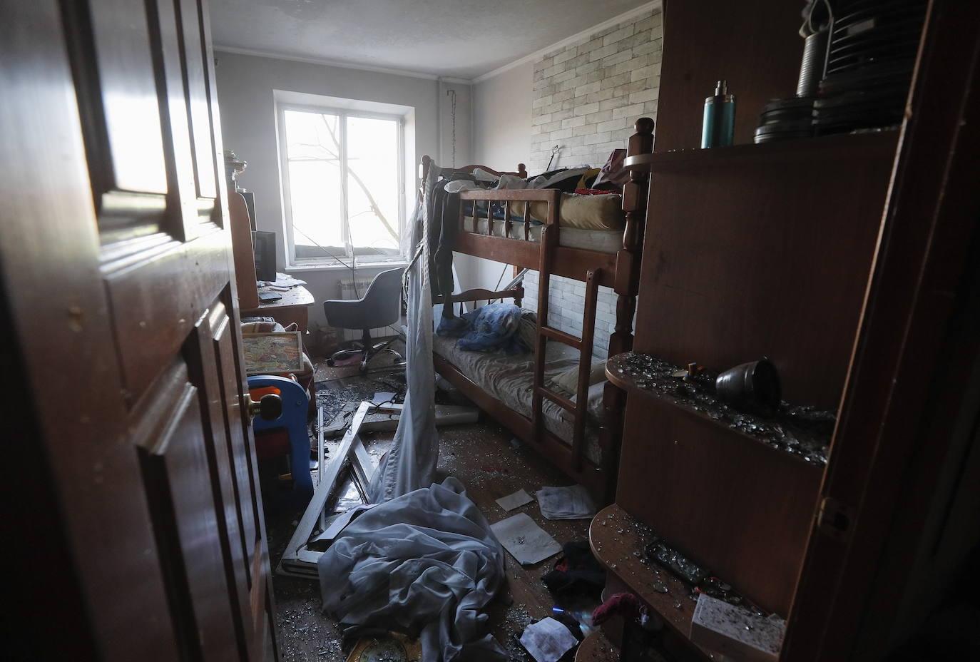 Bomberos ucranianos trabajan dentro de un edificio dañado después de un bombardeo en Kharkiv, Ucrania.