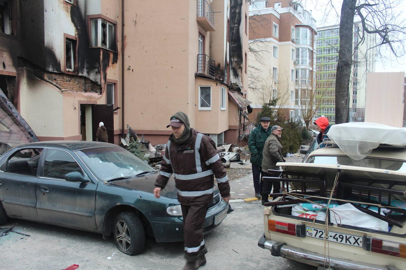 Voluntarios de Irpín ayudan a evacúar a las personas de un edificio que ha sido bombardeado.