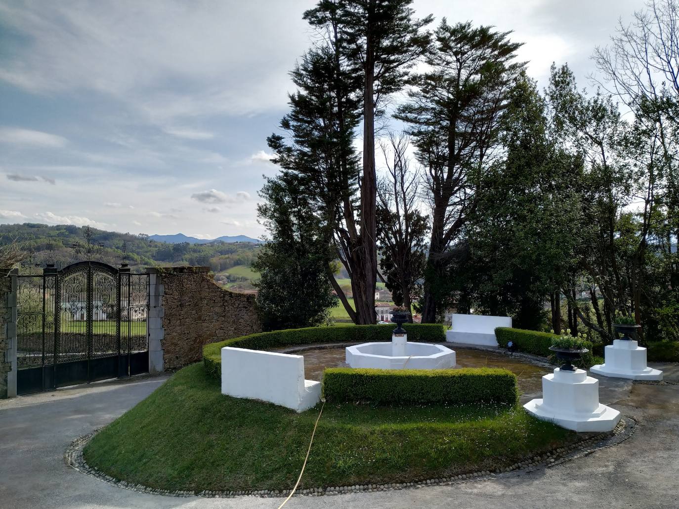 Fuente de estilo andaluz, una dentro de otra. Antiguamente un templete cubría la fuente central. Detrás está la entrada principal de la finca.