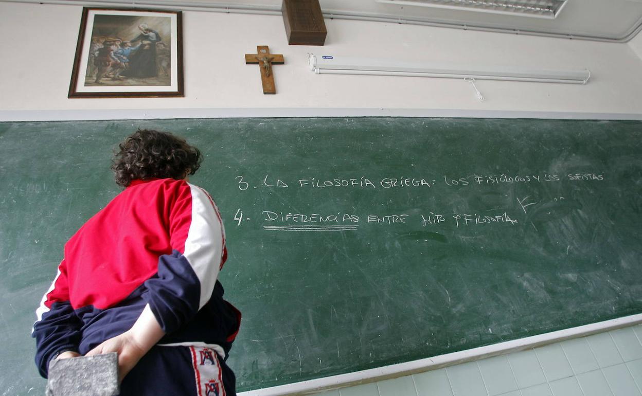 n niño, en un aula de Oviedo, con el crucifijo sobre la pizarra. 