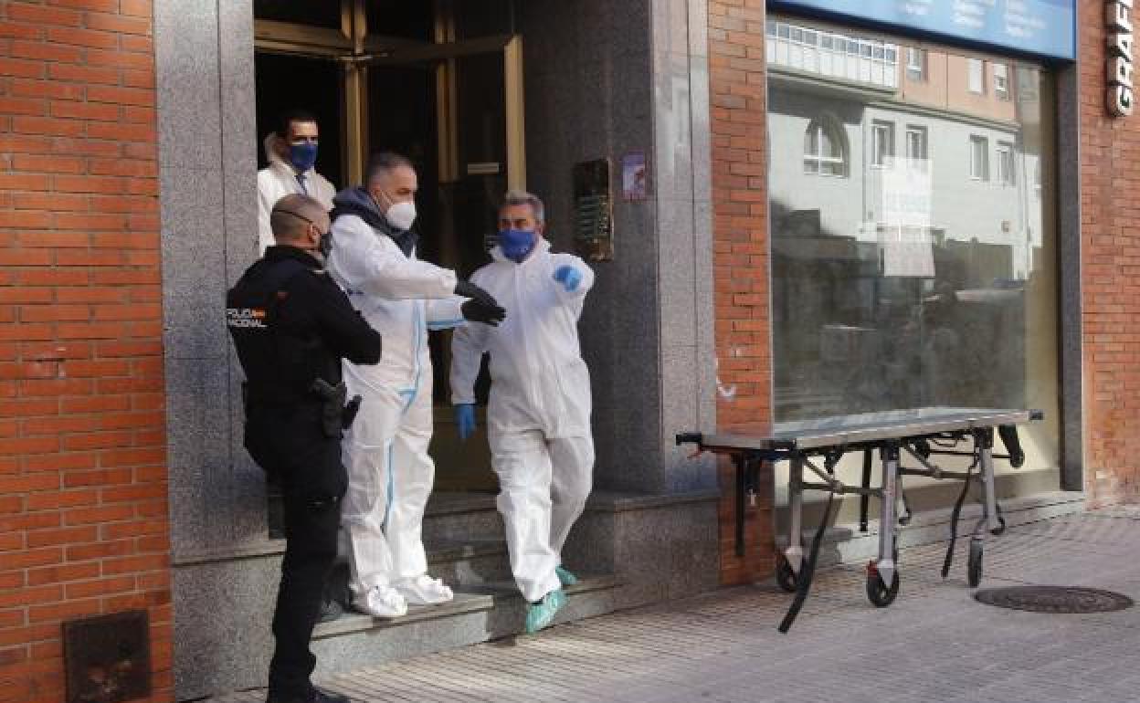 Agentes de la Científia y de la Nacional, en el portal donde sucedió el crimen, el pasado martes. 