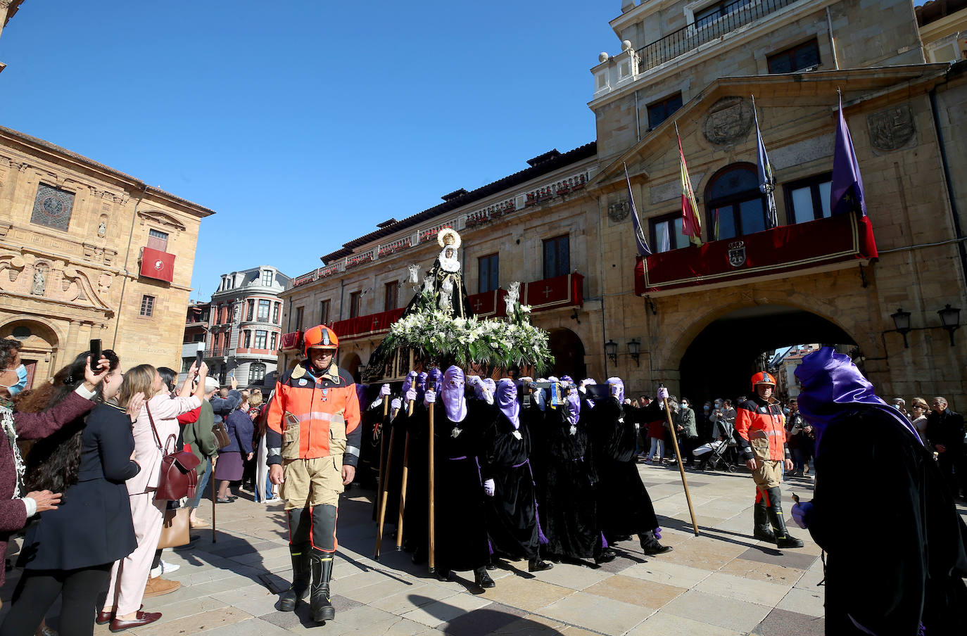 La procesión de La Soledad, escoltada por cuatro bomberos, se abrió paso entre aplausos hasta llegar a la plaza del Ayuntamiento de Oviedo. Los miembros de la Real y Trinitaria Archicofradía del Santo Entierro y Nuestra Señora de Los Dolores en su Inmaculada Concepción han recorrido durante dos horas el casco antiguo, dedicando este acto a las víctimas de la pandemia y de la guerra en Ucrania