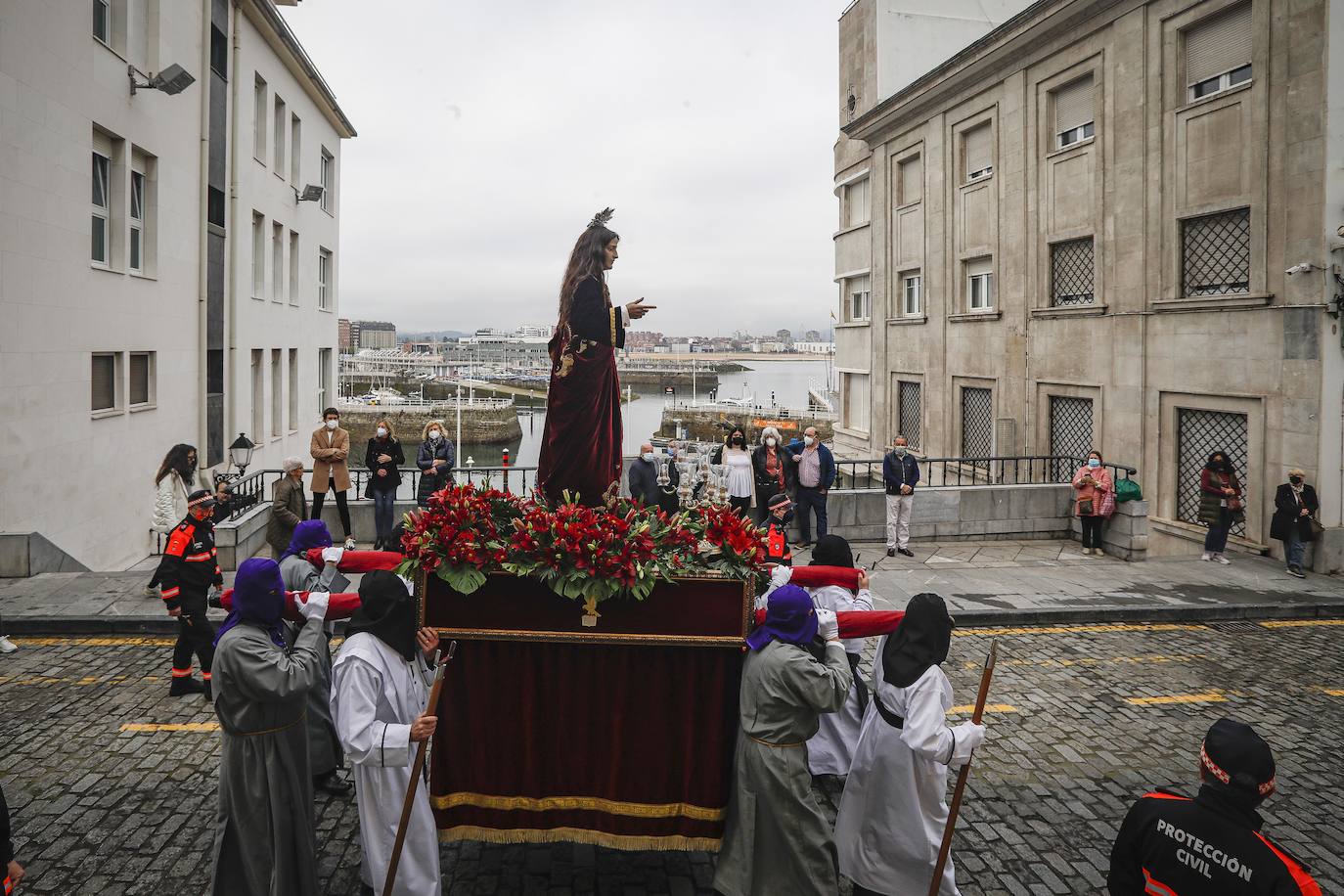 La Ilustre Hermandad de la Santa Vera Cruz abrió camino desde el Campo Valdés para dirigirse a Sebastián Miranda, seguidos por la Hermandad de la Misecordia, portadora de la imagen de San Juan Evangelista y, tras ellos, los integrantes de la Ilustre Cofradía del Santo Sepulcro portaban sobre sus hombros a la virgen de la Soledad, rodeada de flores blancas y ataviada con un manto azul noche y bordados dorados.